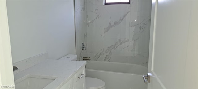 full bathroom featuring tiled shower / bath combo, vanity, and toilet