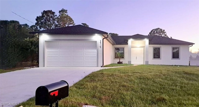 single story home with a garage and a lawn