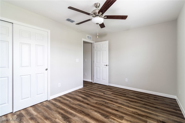 unfurnished bedroom featuring a closet, ceiling fan, and dark hardwood / wood-style flooring