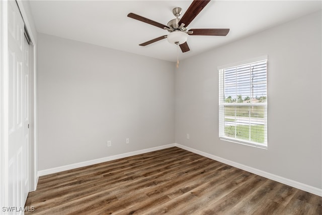 unfurnished room featuring ceiling fan and dark wood-type flooring