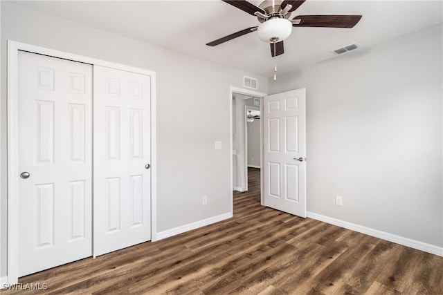 unfurnished bedroom featuring ceiling fan, dark wood-type flooring, and a closet