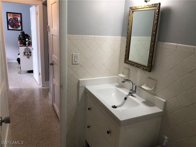 bathroom featuring vanity and tile walls