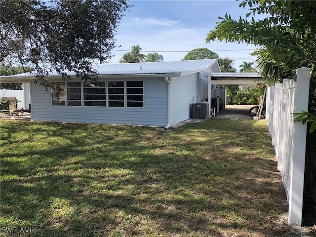 exterior space with a yard, a carport, and cooling unit