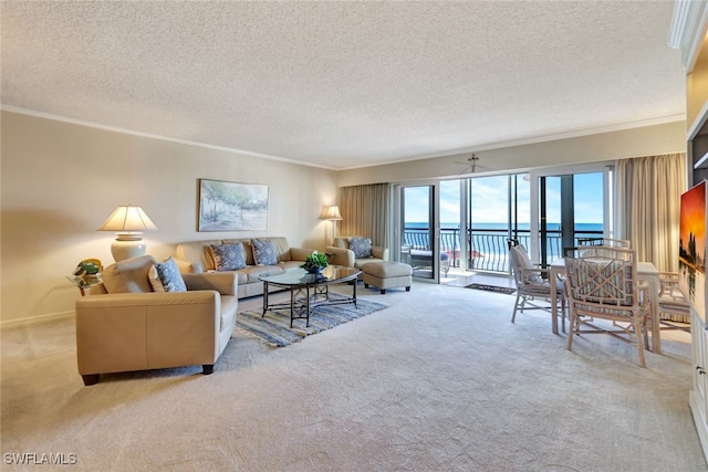 carpeted living room with a textured ceiling, a water view, ceiling fan, and ornamental molding