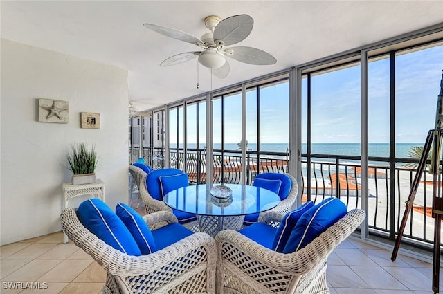 sunroom / solarium featuring a water view and ceiling fan