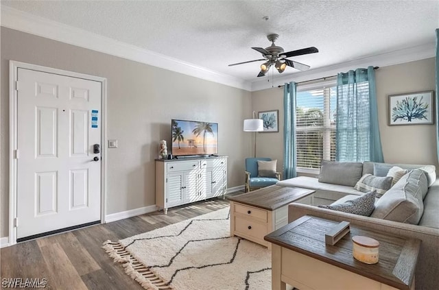 living room featuring crown molding, ceiling fan, dark hardwood / wood-style flooring, and a textured ceiling