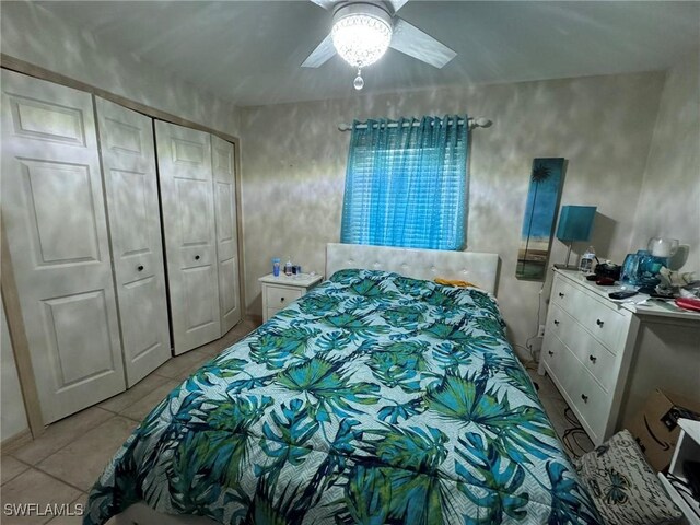 bedroom with light tile patterned flooring, a closet, and ceiling fan