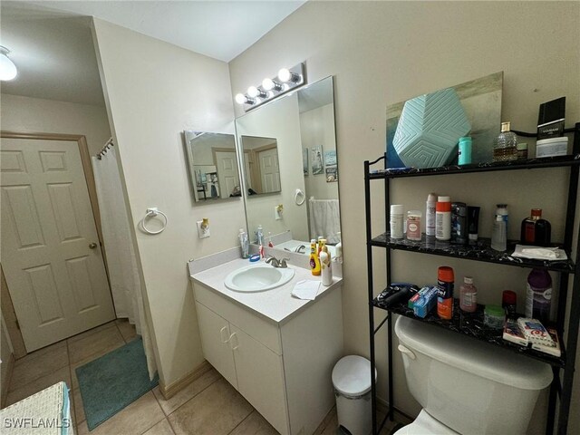 bathroom featuring tile patterned flooring, vanity, and toilet