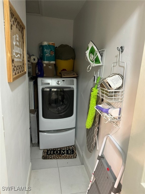 clothes washing area with tile patterned floors and washer / dryer