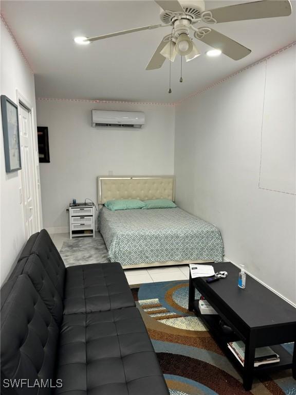 bedroom featuring a wall mounted AC and ceiling fan