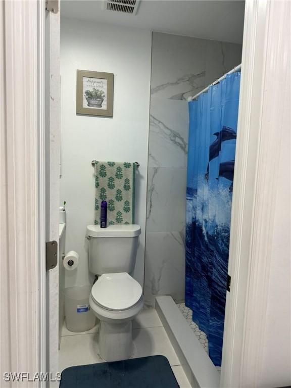 bathroom with curtained shower and toilet