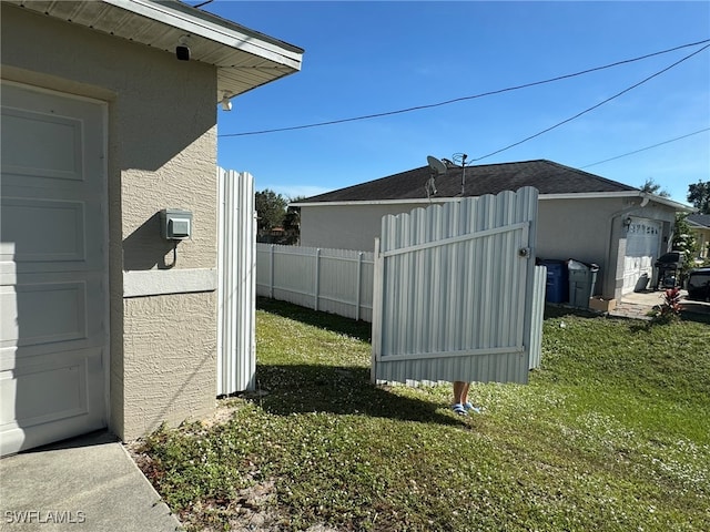 view of side of home with a yard and a garage