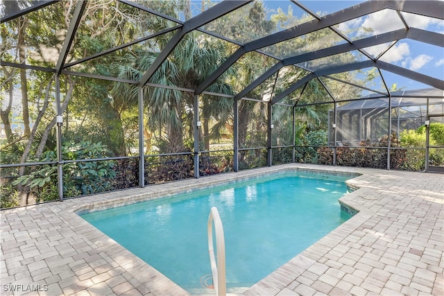 view of swimming pool featuring a lanai and a patio