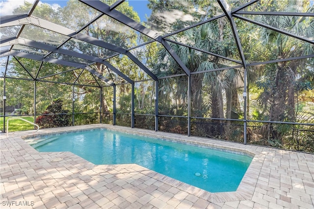 view of swimming pool featuring glass enclosure and a patio