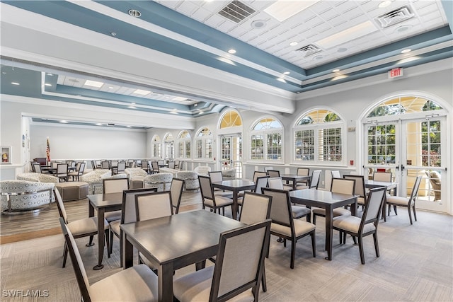 dining space featuring french doors, a tray ceiling, and crown molding