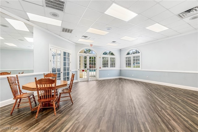 dining space featuring french doors, a drop ceiling, dark hardwood / wood-style floors, and ornamental molding