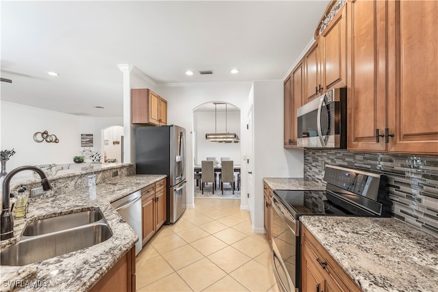 kitchen featuring sink, light stone counters, backsplash, light tile patterned floors, and appliances with stainless steel finishes