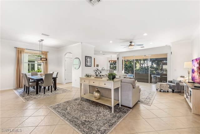 tiled living room featuring ceiling fan and ornamental molding