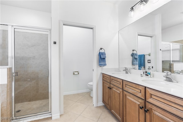 bathroom featuring tile patterned flooring, vanity, toilet, and an enclosed shower