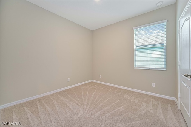 spare room featuring light carpet