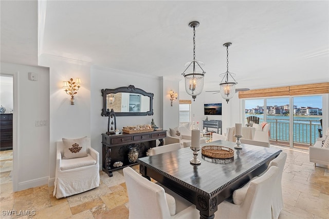 dining area featuring crown molding, a water view, and an inviting chandelier