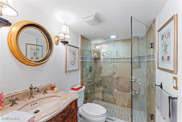 bathroom featuring vanity, toilet, and an enclosed shower