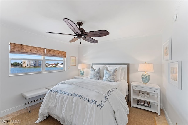 bedroom featuring ceiling fan, crown molding, and a water view