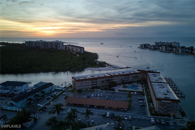 aerial view at dusk featuring a water view