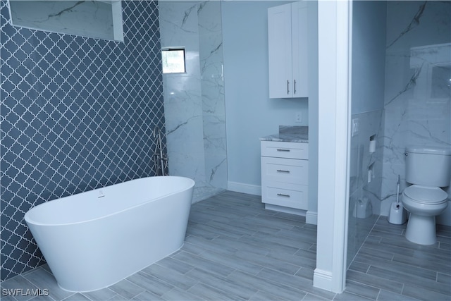 bathroom with a bathing tub, hardwood / wood-style floors, tile walls, and toilet