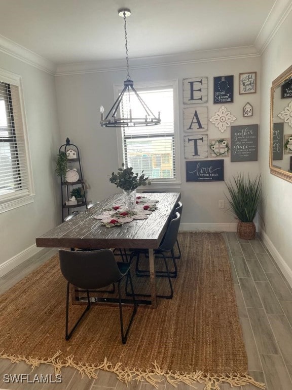 dining room with a chandelier, wood-type flooring, plenty of natural light, and ornamental molding