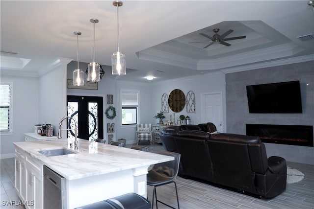 kitchen with white cabinets, a wealth of natural light, sink, and hanging light fixtures