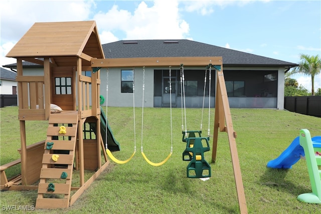 view of playground with a sunroom and a yard