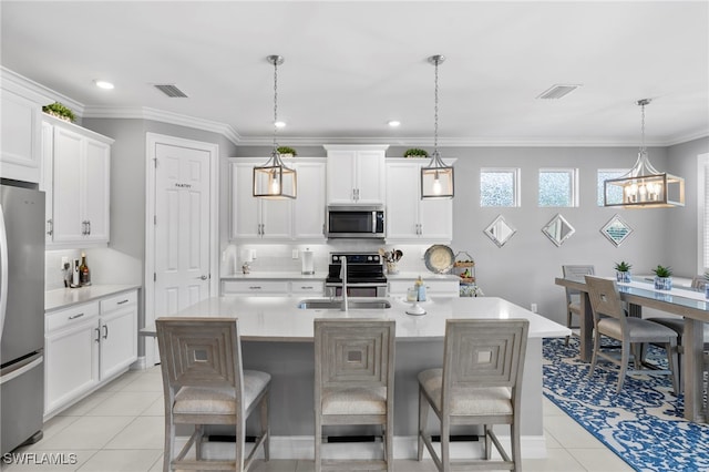 kitchen with a kitchen breakfast bar, stainless steel appliances, hanging light fixtures, and a center island with sink