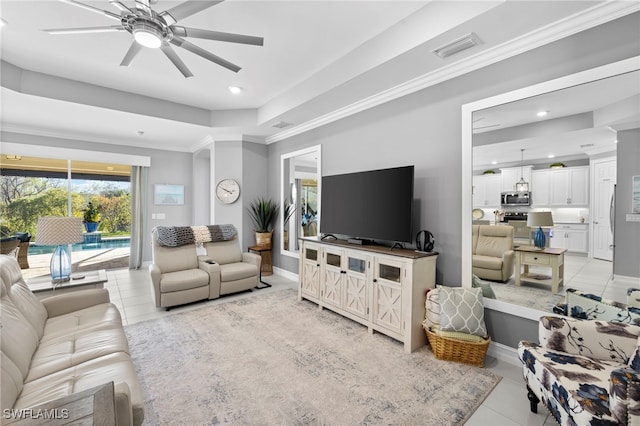 tiled living room featuring crown molding, a raised ceiling, and ceiling fan