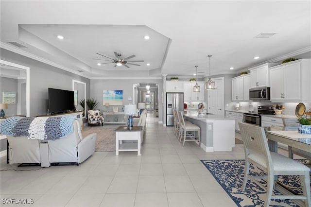 tiled living room featuring crown molding, ceiling fan, and a tray ceiling