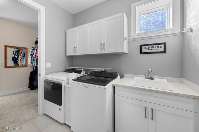 laundry room with separate washer and dryer, sink, light colored carpet, and cabinets