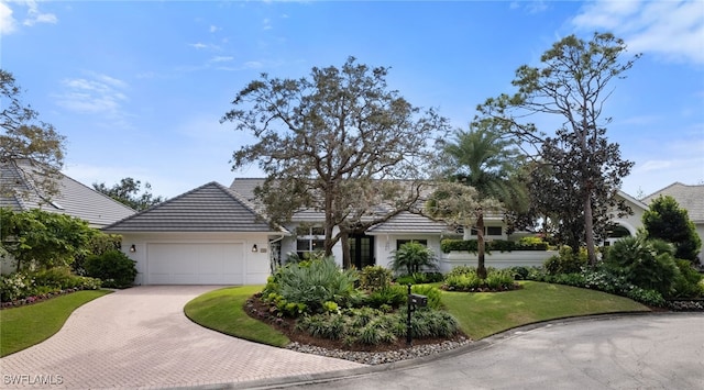 view of front of home with a garage and a front lawn