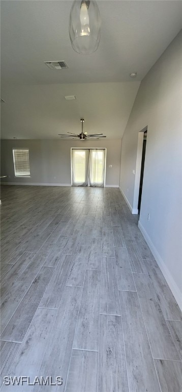 empty room with ceiling fan, light hardwood / wood-style flooring, and lofted ceiling