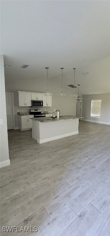 kitchen with light wood-type flooring, decorative light fixtures, white cabinetry, and a center island with sink