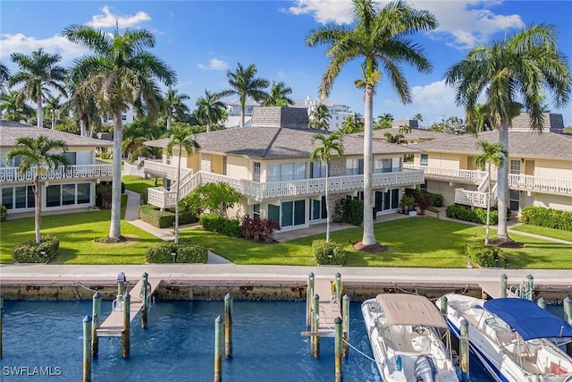 back of property with a yard and a water view