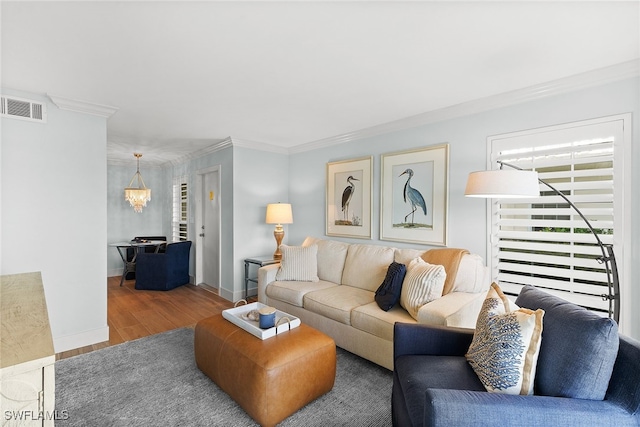 living room featuring crown molding, hardwood / wood-style floors, and an inviting chandelier