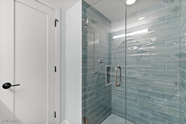 bathroom featuring a shower with door