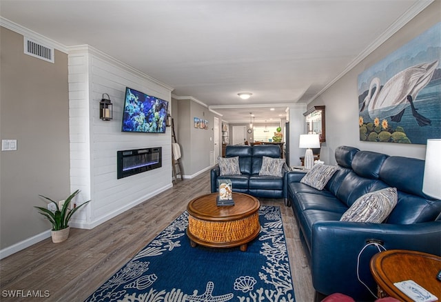 living room with hardwood / wood-style flooring, crown molding, and a fireplace