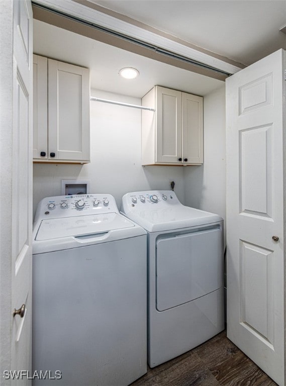 laundry area with cabinets, washer and clothes dryer, and dark wood-type flooring