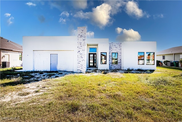 view of front facade with central AC and a front lawn