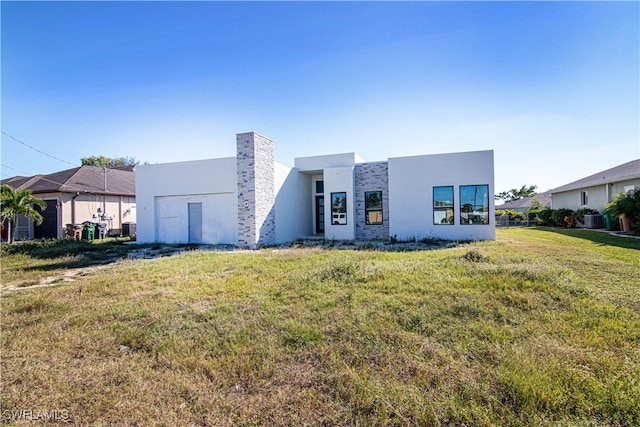 contemporary home with central air condition unit and a front lawn