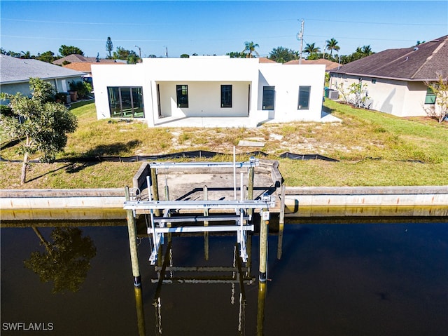 back of house featuring a water view, a yard, and a patio