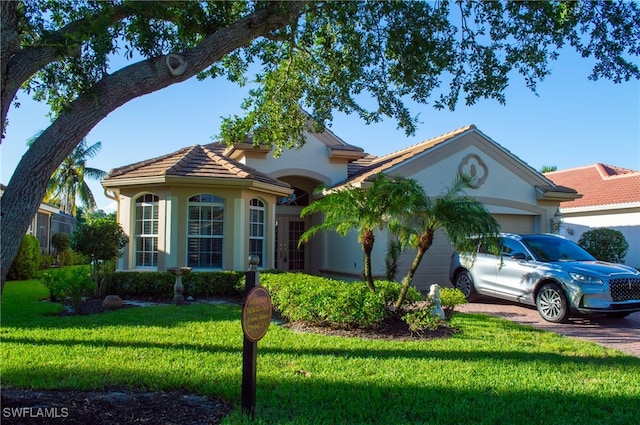 mediterranean / spanish-style house with a garage and a front yard