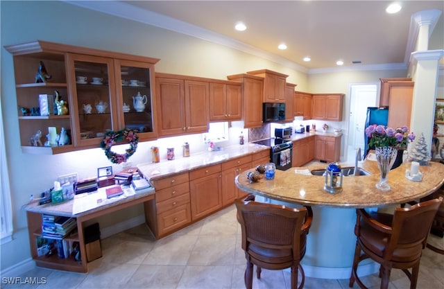 kitchen with sink, crown molding, a breakfast bar area, light tile patterned floors, and black appliances