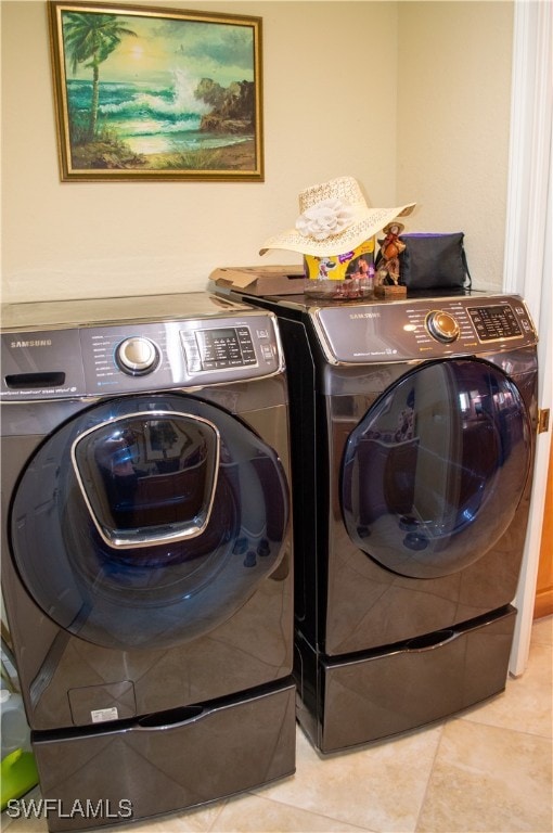 washroom with light tile patterned floors and washer and dryer